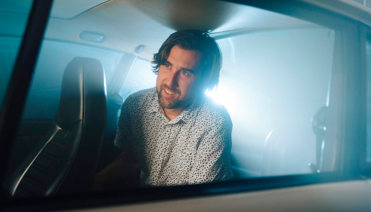 Kevin McCauley headshot in a car with haze and backlit by dramatic blue-white light
