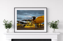 Load image into Gallery viewer, Framed image on white wall of Porsche 992 911 being loaded onto a DHL 747
